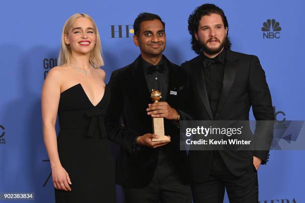 Actors Emilia Clarke and Kit Harington pose with Aziz Ansari and his award for Best Performance by an Actor in a Television Series Musical or Comedy...