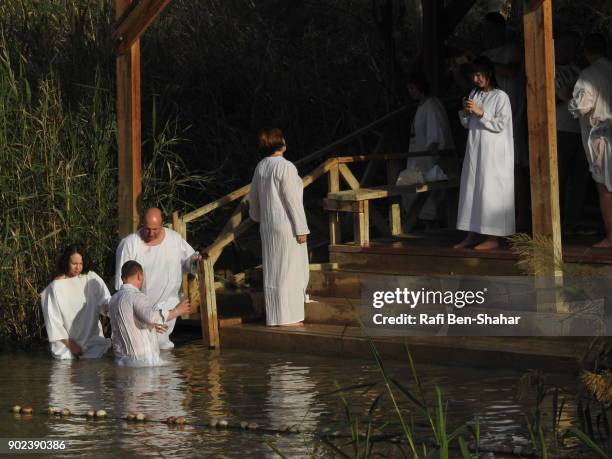 christian baptism in the jordan river jordan side - dopdräkt bildbanksfoton och bilder