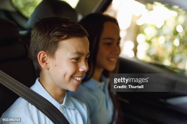 young boy putting on seat belt - first day of school australia stock pictures, royalty-free photos & images