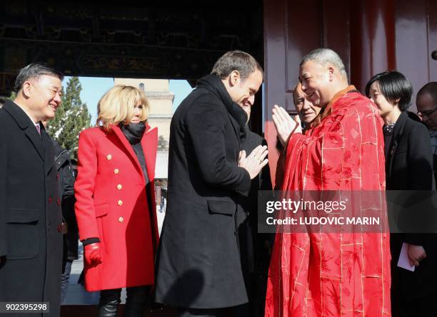 French President Emmanuel Macron and his wife Brigitte Macron are greeted by a monk during a visit at the Big Wild Goose Pagoda in the northern...