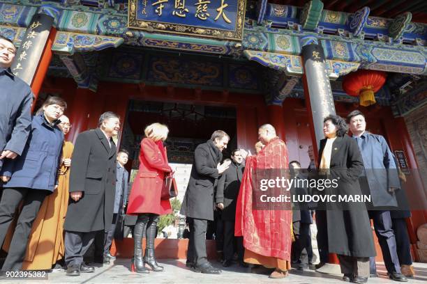 French President Emmanuel Macron and his wife Brigitte Macron are greeted by a monk during a visit at the Big Wild Goose Pagoda in the northern...