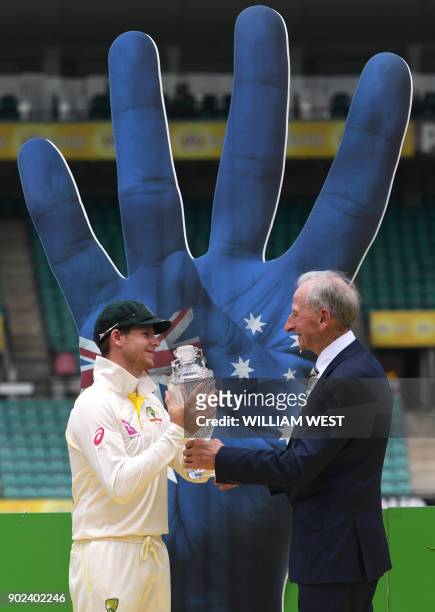Australia's captain Steve Smith receives a vase from former Australian cricket Bill Lawry after Australia defeated England and retained the Ashes on...