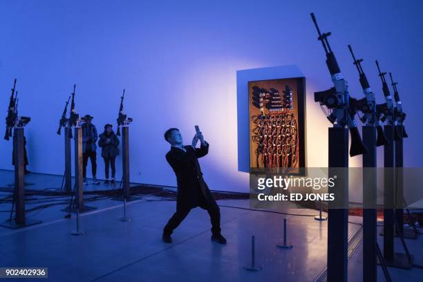 In this photo taken on January 8, 2018 a man takes a photo at an exhibition entitled 'Mirror Organs: Play of Metonymy' by South Korean artist Kelvin...