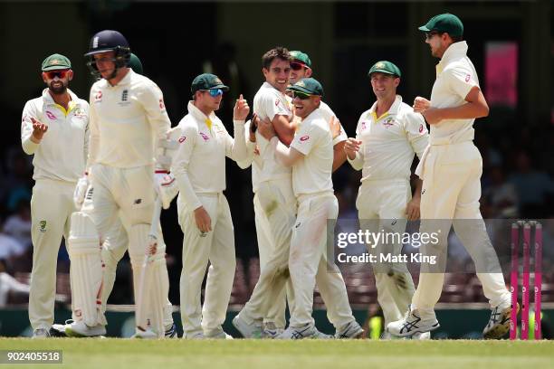 Pat Cummins of Australia celebrates with team mates after taking the wicket of Mason Crane of England during day five of the Fifth Test match in the...