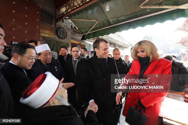 Brigitte Macron , wife of French President Emmanuel Macron , shakes hands with an elderly iman during a visit to the Great Mosque of Xian in the...