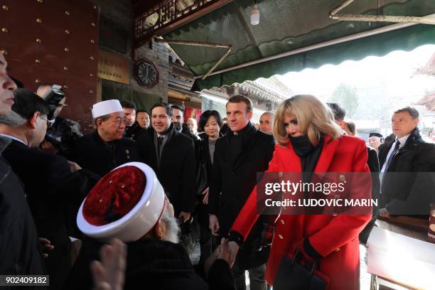 Brigitte Macron , wife of French President Emmanuel Macron , shakes hands with an elderly iman during a visit to the Great Mosque of Xian in the...