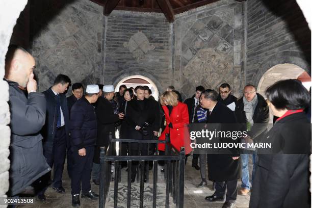 French President Emmanuel Macron and his wife Brigitte Macron are given a tour during a visit to the Great Mosque of Xian in the northern Chinese...