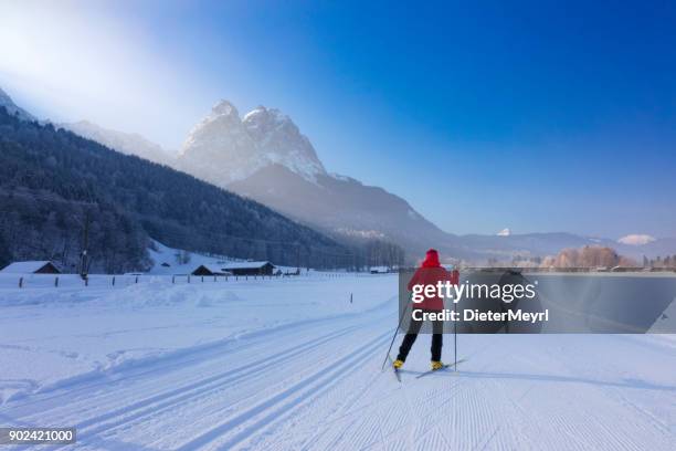 langlaufen sie in richtung berg zugspitze - cross country skis stock-fotos und bilder