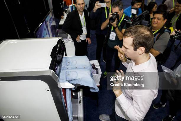 An attendee tries a FoldiMate Inc. robotic laundry folding machine News  Photo - Getty Images