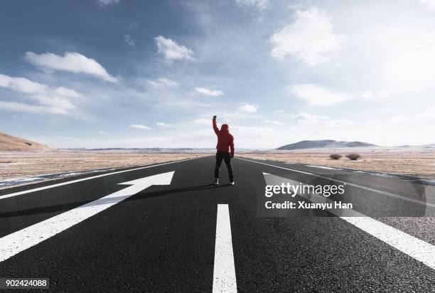 man stands on long road - wide arrow stock pictures, royalty-free photos & images