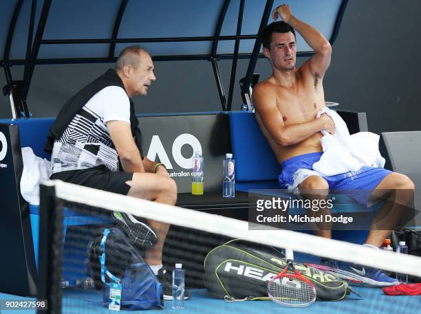 Bernard Tomic of Australia talks with his father JohnTomic during a practice session ahead of the 2018 Australian Open at Melbourne Park on January...