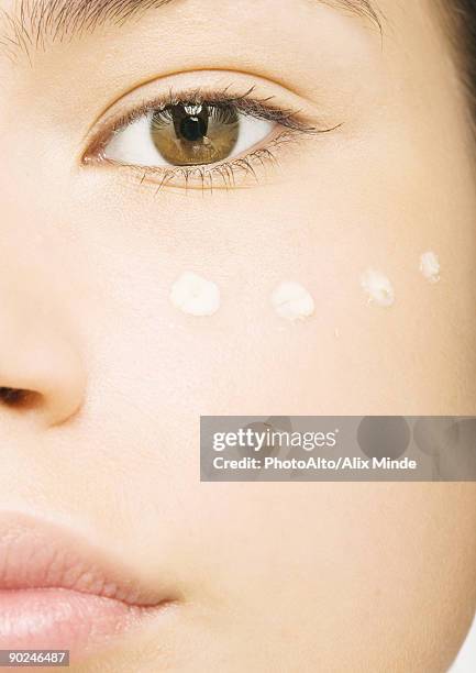 woman's face with concealer under eye, close-up - concealer foto e immagini stock