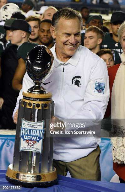 Michigan State Spartans head coach Mark Dantonio lifts the SDCCU Holiday Bowl Trophy after the Spartans defeated the Washington State Cougars 42 to...