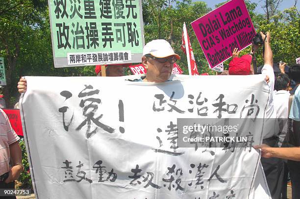 Protester holds a banner reading "Dalai Lama political monk, get out" as protesters stage a rally during a visit by the Dalai Lama to Taiwan, in...