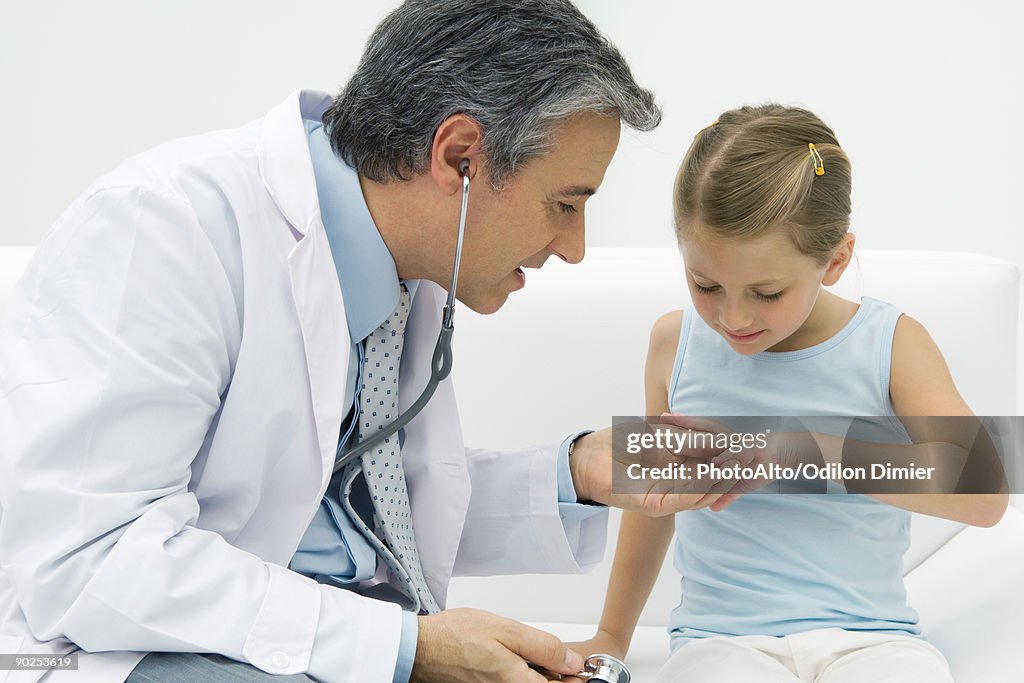 Doctor examining girl's fingers
