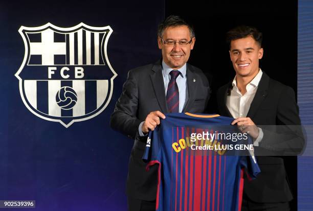Barcelona's new Brazilian midfielder Philippe Coutinho poses with his new jersey beside Barcelona FC President Josep Maria Bartomeu during his...