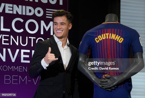 New Barcelona signing Philippe Coutinho poses for a photograph next to his new shirt as he is unveiled at Camp Nou on January 8, 2018 in Barcelona,...