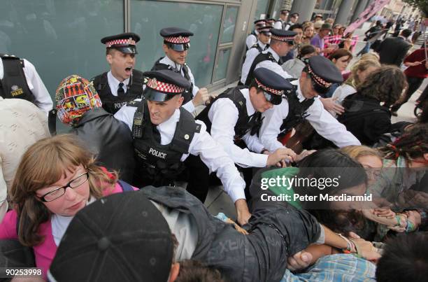 Police attempt to push climate change protesters away from the entrance to The Royal Bank of Scotland's headquarters on September 1, 2009 in London,...