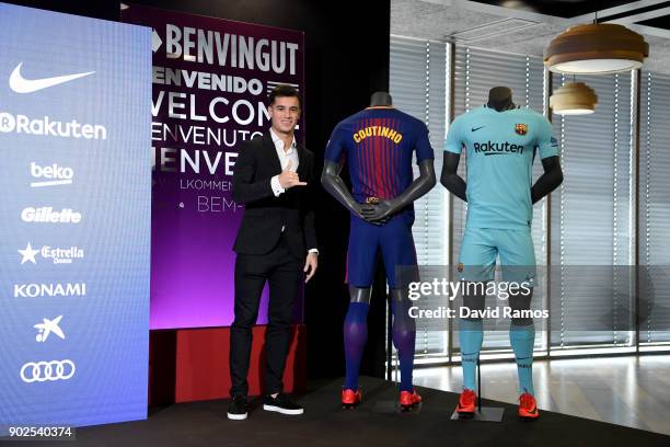 New Barcelona signing Philippe Coutinho poses for a photograph next to his new shirt as he is unveiled at Camp Nou on January 8, 2018 in Barcelona,...