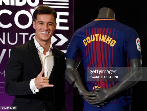 Barcelona's new Brazilian midfielder Philippe Coutinho poses with his new jersey during his official presentation in Barcelona on January 8, 2018....