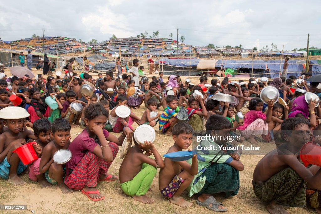 Rohingya children wait for food aid near the Thengkhali...