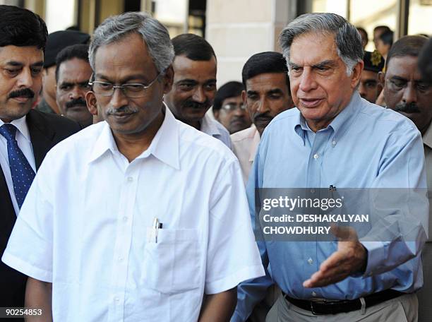 West Bengal state Industrial Minister Nirupam Sen and Tata Group Chairman Ratan Tata make their way to a press meet in Kolkata on September 1, 2009....
