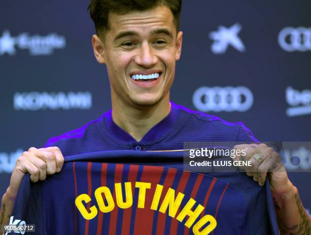 Barcelona's new Brazilian midfielder Philippe Coutinho shows his new jersey before holding a press conference in Barcelona on January 8, 2018....