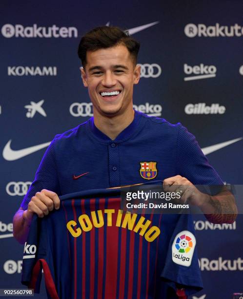New Barcelona signing Philippe Coutinho poses for a photograph with his new shirt as he is unveiled at Camp Nou on January 8, 2018 in Barcelona,...