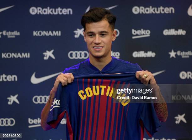 New Barcelona signing Philippe Coutinho poses for a photograph with his new shirt as he is unveiled at Camp Nou on January 8, 2018 in Barcelona,...