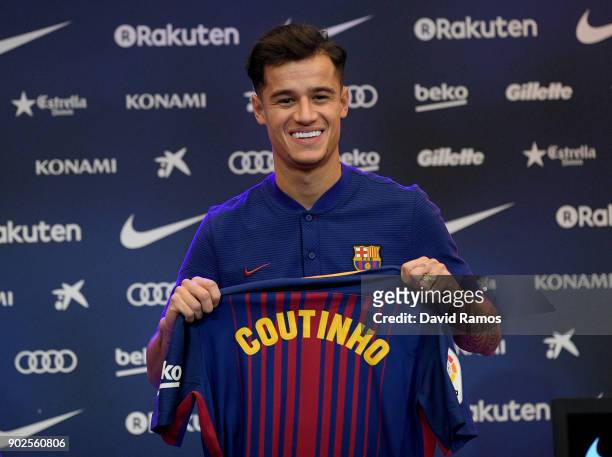 New Barcelona signing Philippe Coutinho poses for a photograph with his new shirt as he is unveiled at Camp Nou on January 8, 2018 in Barcelona,...