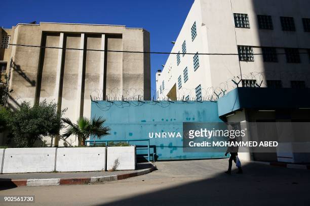 Palestinian man walks past the building of the UNRWA headquarters in Gaza City on January 8, 2018. - Israeli Prime Minister Benjamin Netanyahu called...