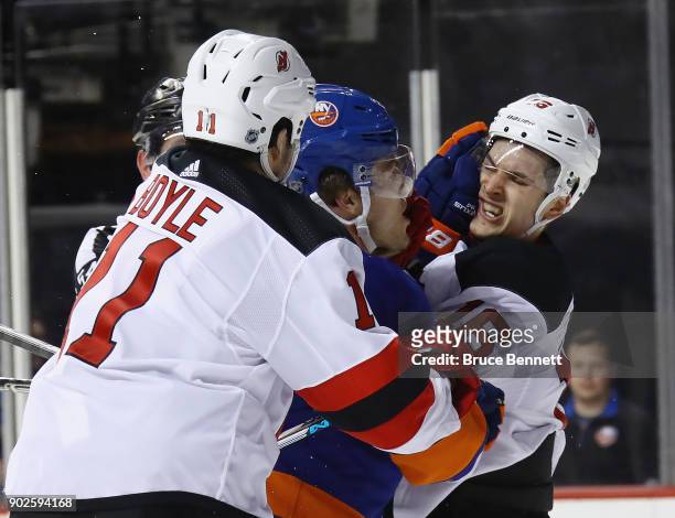Anders Lee of the New York Islanders gets the glove up on Steven Santini of the New Jersey Devils at the Barclays Center on January 7, 2018 in the...