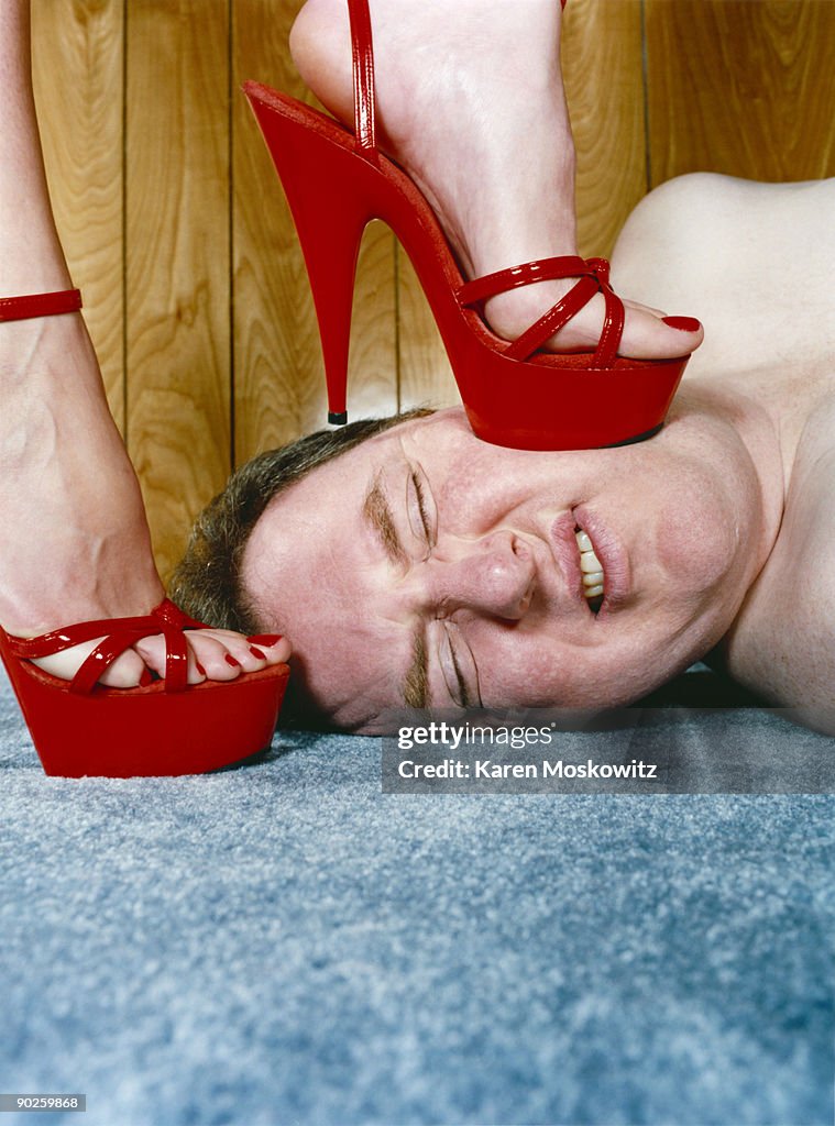 Woman stepping on man