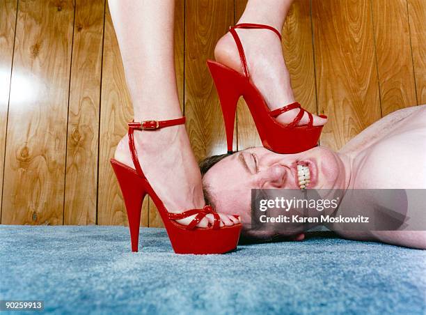 woman stepping on man - risque woman stock pictures, royalty-free photos & images