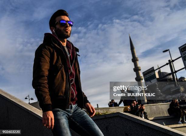 Pedestrians walks in sunshine on a stairway at Eminonu District in Istanbul on January 8, 2018. / AFP PHOTO / BULENT KILIC