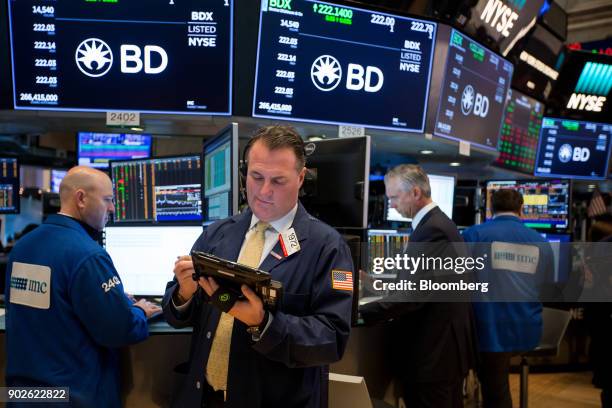 Traders work on the floor of the New York Stock Exchange in New York, U.S., on Monday, Jan. 8, 2018. U.S. Stocks were mixed, with the S&P 500 Index...