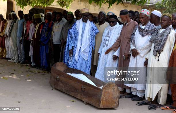 Men pray next to a coffin on January 7, 2018 in a mosque in the regional capital Ziguinchor, southern Senegal following an attack by armed men in the...