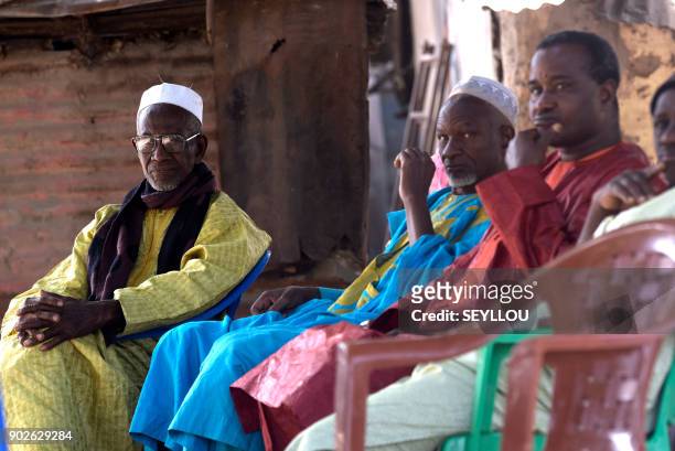 People sit during the funerals of a victim of an attack by armed men in the Bayotte forest, in the regional capital Ziguinchor, southern Senegal on...