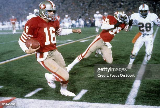 Joe Montana of the San Francisco 49ers runs with the ball and heads out of bounds after getting enough yardage for the first down against the Miami...