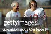Quarterback Joe Montana and head coach Bill Walsh of the San Francisco 49ers share a laugh during a practice circa 1980's.