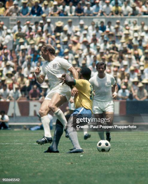 Bobby Charlton of England clashes with Pele of Brazil as Alan Mullery looks on during the FIFA World Cup match between Brazil and England at the...