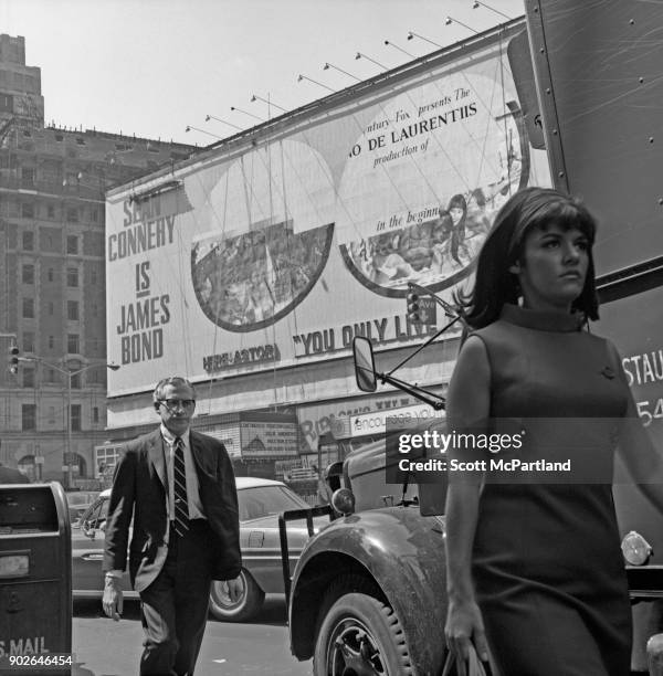 Man stares intensely as he follows a young woman walking a few steps ahead of him in Times Square, New York across the street from the Astor movie...