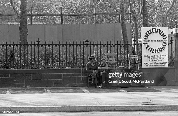 Shoe shiner sits in a chair, and waits for his next customer on Sixth avenue near Times Square, New York.