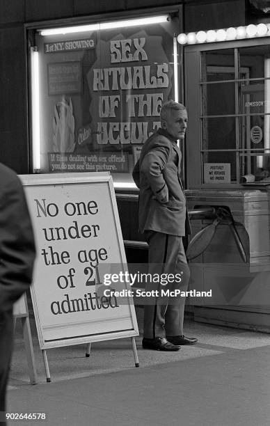 An usher stands near the box office of a movie theater on 42nd street screening pornography films in Times Square, New York.