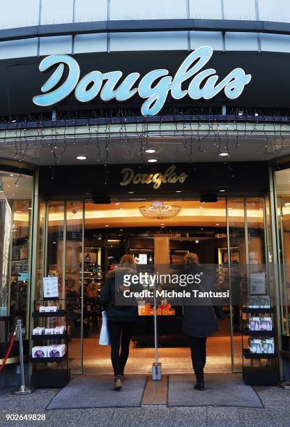 Pedestrians enter a Douglas parfum shop on January 8, 2018 in Berlin, Germany. According to government statisticians, nominal revenue grew compared...