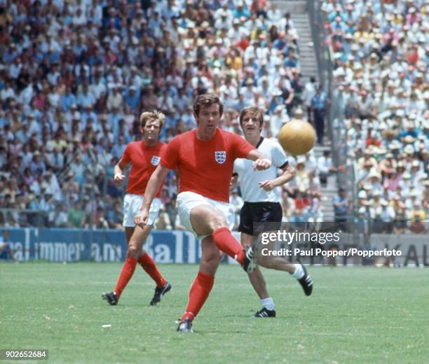 England's Alan Mullery plays the ball forward watched by Keith Newton and Germany's Johannes Lohr during the FIFA World Cup quarter final match...