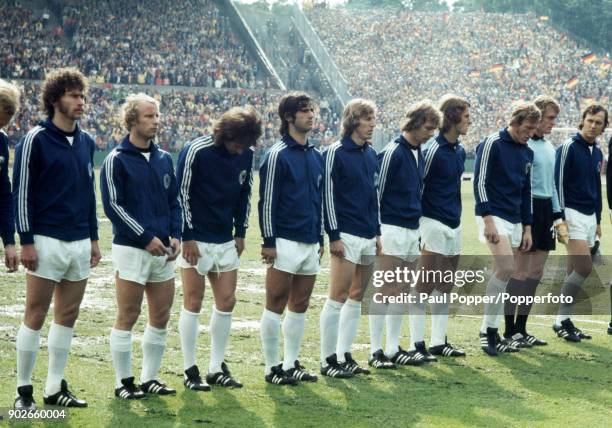 The West German team line up for the National Anthems prior to the FIFA World Cup match between Poland and West Germany at the Waldstadion in...