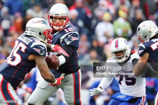 Tom Brady of the New England Patriots hands off the ball to Mike Gillislee during a game against the Buffalo Bills at Gillette Stadium on December...