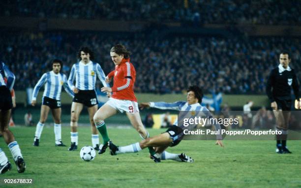 Andras Torocsik of Hungary is tackled by Argentina captain Daniel Passarella, during the FIFA World Cup match between Argentina and Hungary at the...