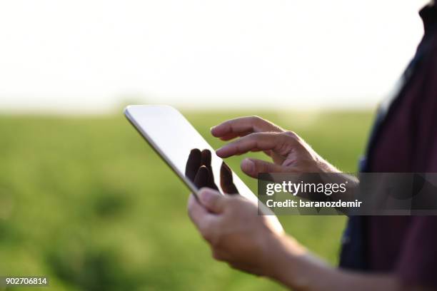 young farmer mit einem digitalen tablet - application modernization stock-fotos und bilder